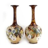 A pair of late 19th century Doulton Lambeth bottle vases tubeline decorated with floral blooms on a