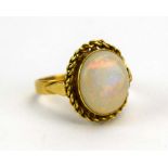 An 18ct yellow gold ring set oval opal in a ropetwist border, ring size Q, 4.