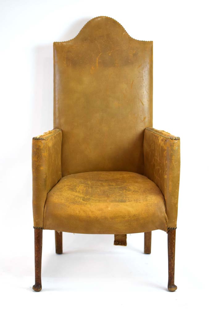 An early 20th century highback leather and studded armchair on tapering legs with pad feet,