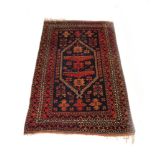 A rug, the red ground with a large stylised medallion within matching bands,