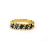 A modern 18ct yellow gold ring set five diagonally set baguette cut sapphires and twelve small