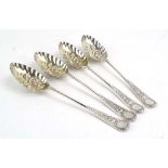 A set of four Edwardian silver and parcel gilt berry spoons,