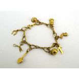 An 18ct yellow gold fancy link bracelet suspending eight yellow metal charms including a cat,