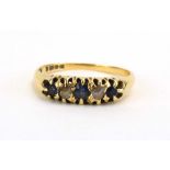 A late 19th/early 20th century 18ct yellow gold ring set three graduated sapphires interspersed