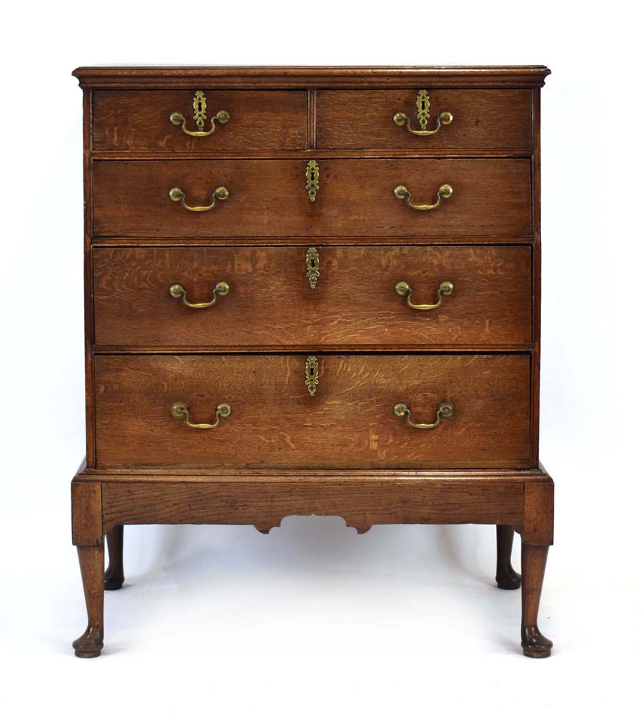 A Georgian oak chest-on-stand, one of the two short drawers with an interior fitted for cutlery,