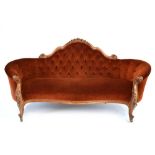 A Victorian mahogany and button upholstered sofa with acanthus carved arms,