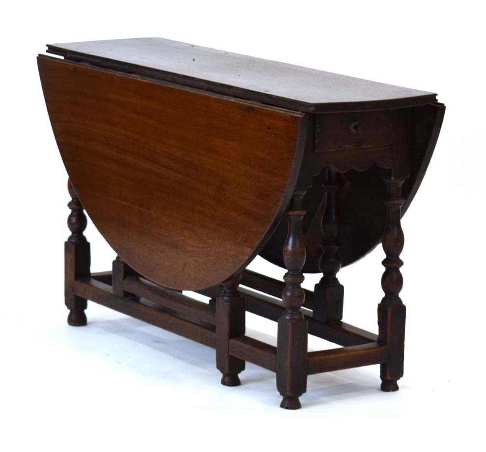 An 18th century oak gateleg table with a single frieze drawer on turned supports joined by - Image 2 of 5