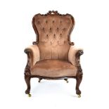 A Victorian mahogany and button upholstered armchair with scrolled arms and feet,