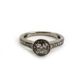 A platinum 'halo' ring set centrally with a brilliant cut diamond within a border of smaller