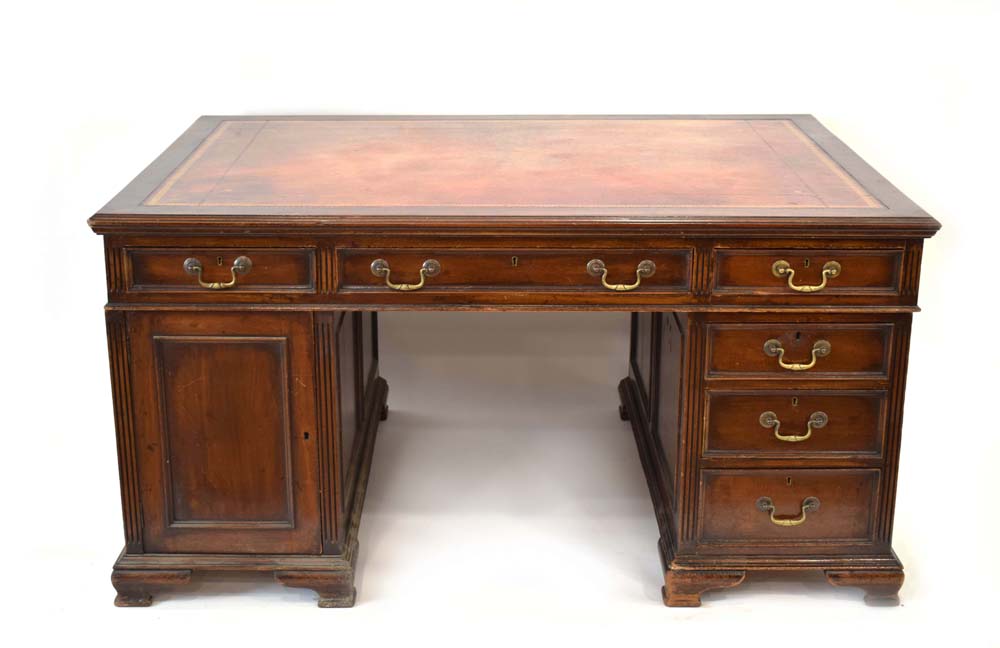 A late 19th/early 20th century mahogany and tooled leather partner's desk on plinth bases,