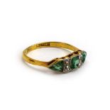 An early 20th century 18ct yellow gold and platinum highlighted ring set step cut emerald,