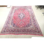 A 20th century rug, the red ground with a central medallian and matching bands,