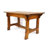 A Commercial Arts & Crafts oak refectorary-type table with a shaped frieze and cross stretcher, l.