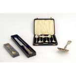 A cased set of six silver teaspoons, an American metalware sifting spoon,