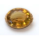 An early 20th century brooch of oval form set facet cut citrine, w. 2.