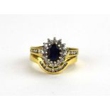 An 18ct yellow gold sapphire and diamond cluster ring, the shoulders each set four small diamonds,