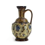 A late 19th century Doulton Lambeth ewer decorated with scrolled leaves and flowerheads on a