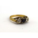 A 9ct yellow gold ring set dark sapphire and two small diamonds in illusion settings,