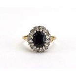 A 9ct yellow gold cluster ring set oval sapphire in a surround of small diamonds, ring size N,