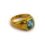 An 18ct yellow gold signet ring set pale blue stone in a rubover setting, ring size L,