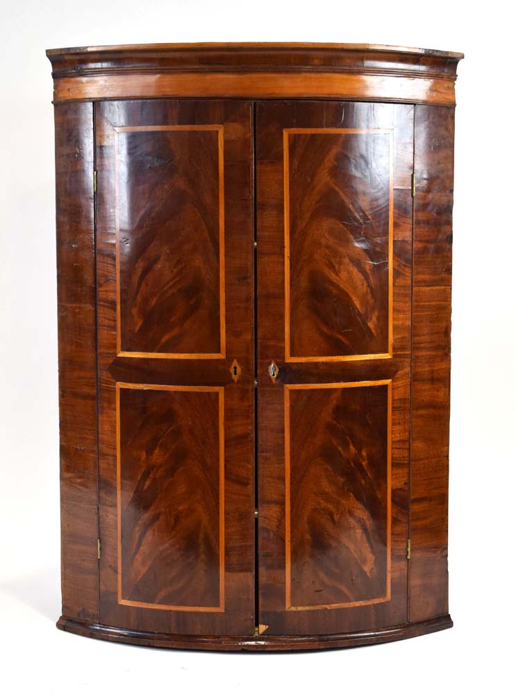 A Georgian mahogany, walnut and crossbanded bow-fronted corner cabinet,