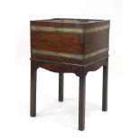 A Georgian mahogany and brass bound open wine cooler of square form with a shaped apron and