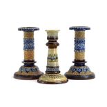 A pair of Doulton Lambeth candlesticks of columnar form,