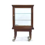 An Edwardian mahogany and four-glass display cabinet on a matching base with brass castors,