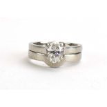 A platinum ring set oval cut diamond in a raised four claw setting,