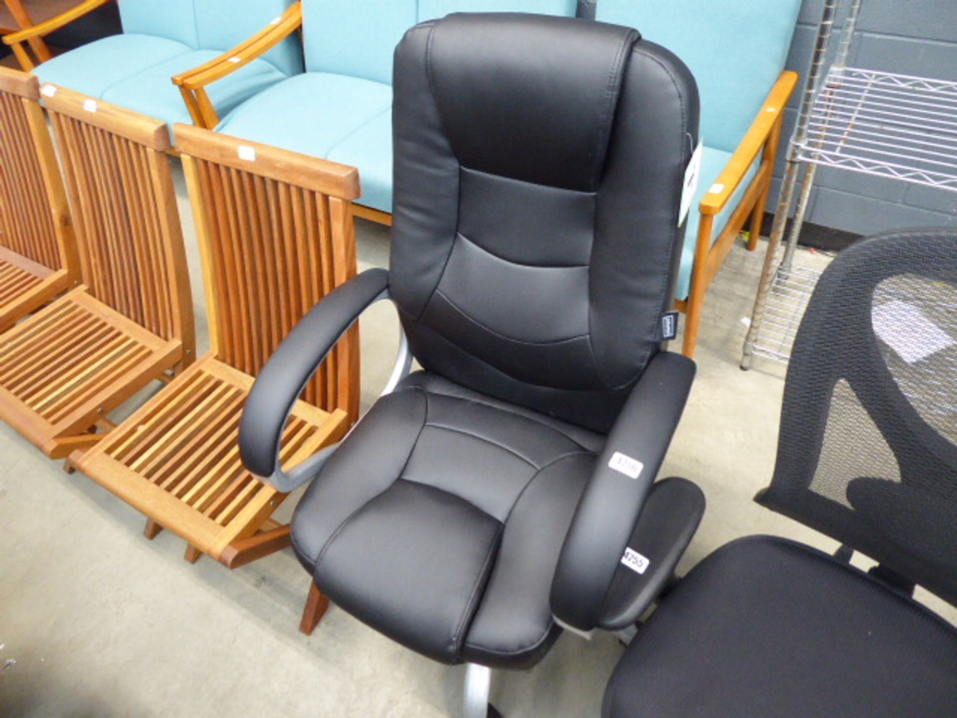 High backed office swivel armchair in black on grey supports