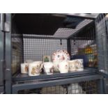 Cage containing commemorative mugs and china plate