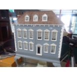Grey painted dolls house on raised cabriole supports