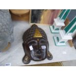 Brown wooden Buddha's mask with gilt decoration