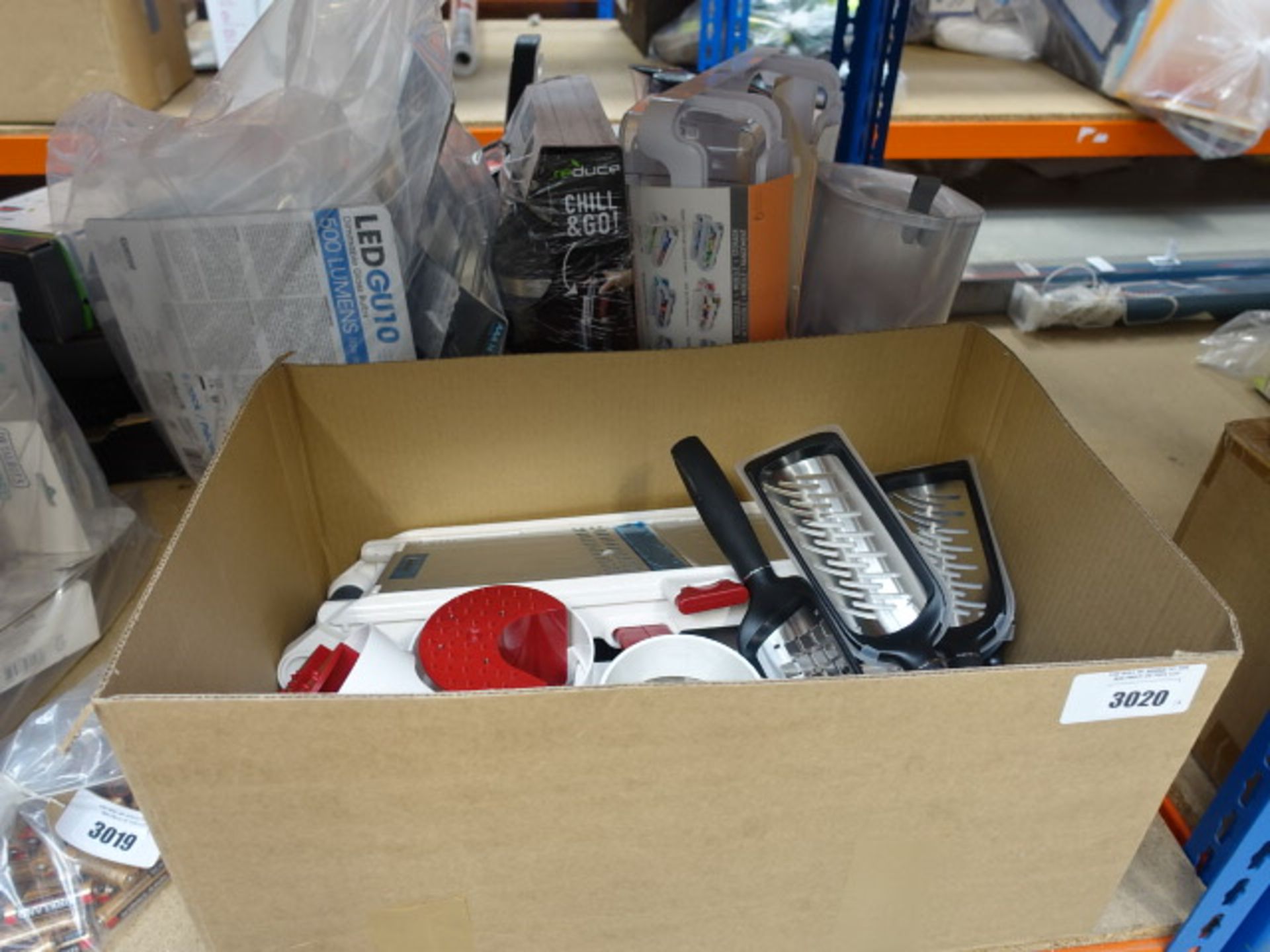 Box containing cheese graters and mixed kitchen items