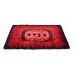 A 1970's red rya rug with 'burnt' borders,
