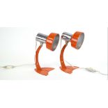 A pair of Danish 1970's orange enamelled desk lamps, with wall-mounting fittings,