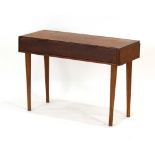 A 1960/70's teak side table, the two drawers with scrolled handles, on circular tapering legs, w.