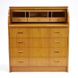 A 1960's Swedish teak bureau, the roll top enclosing a fitted interior, over three long drawers,