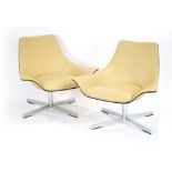 A pair of Matteo Grassi 2Leather cream lowback armchairs on four-star aluminium swivel bases.