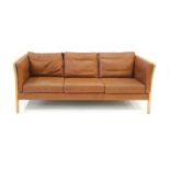 A 1970's three seater sofa with brown cushions and a beech frame, in the manner of Stouby, l.
