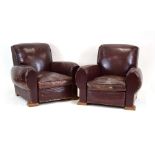 A pair of 1930's club armchairs in burgandy and brown with oak feet