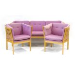 A beech framed three-piece suite in the manner of Stouby including a three-seater sofa and a pair