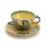 A studio pottery cup and saucer with yellow and blue glazes, moulded RW to base,