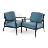 A pair of contemporary ebonised open armchairs with organic-type frames and loose upholstery.