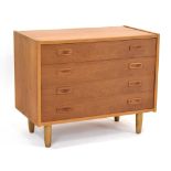 A 1970's teak chest of four drawers with integral handles, on later circular legs, w.
