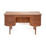 A 1960's Danish designed teak and crossbanded desk with an arrangement of seven drawers on square