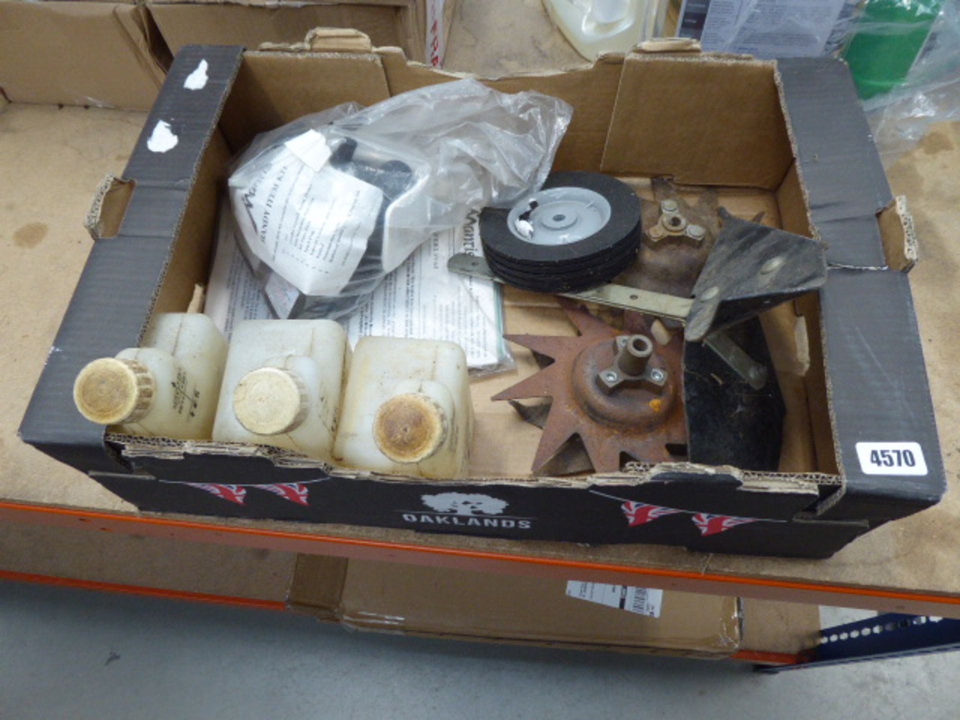 Box containing a quantity of Mantis petrol powered rotivator parts including spare blades, wheels,