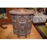 Anglo-Indian heavily octagonal carved side table on a folding base with leaf, flower and berry
