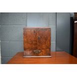 157 A Victorian walnut smokers cabinet, the two doors enclosing two drawers and a compartment,
