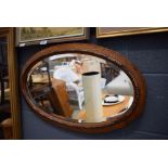 Oval bevelled mirror in oak frame